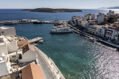 Deniz ve dağların panoramik görüntüsü ve bir drondan çekilen turkuaz su üzerindeki gemiler.