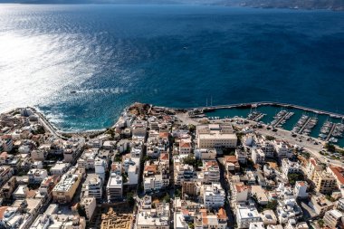Deniz ve dağların panoramik görüntüsü ve bir drondan çekilen turkuaz su üzerindeki gemiler.