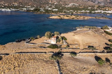 Deniz ve dağların panoramik görüntüsü ve bir drondan çekilen turkuaz su üzerindeki gemiler.