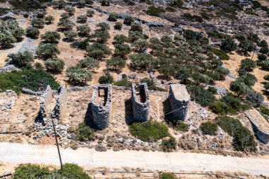 Yüzyıllar öncesine ait değirmenlerin panoramik bir görüntüsü, dağların arka planına ve Girit 'in insansız hava aracından çekilen zeytinliklerine karşı. 