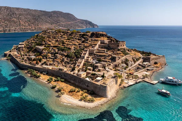 Spinalonga adasının panoramik görüntüsü. Gemiler ve turkuaz deniz insansız hava aracından çekiliyor. 