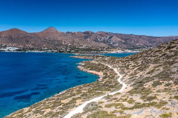 Deniz ve dağların panoramik görüntüsü ve bir drondan çekilen turkuaz su üzerindeki gemiler.