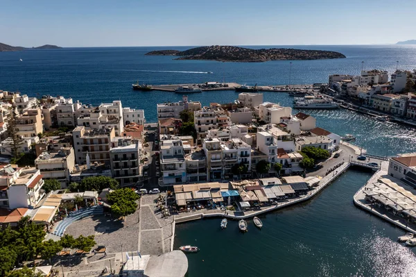 Deniz ve dağların panoramik görüntüsü ve bir drondan çekilen turkuaz su üzerindeki gemiler.