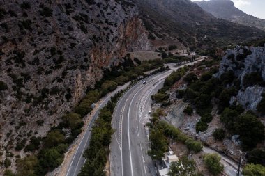 Beyaz taş kilisenin panoramik görüntüsü, dağların arka planına ve Girit 'in zeytinliklerine karşı bir dron tarafından filme alındı. 