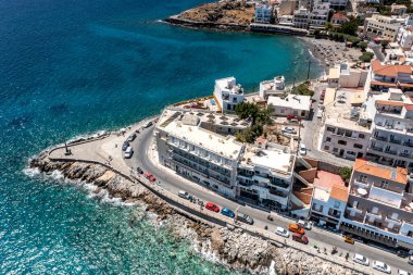 Girit şehrinin panoramik görüntüsü deniz kenarındaki setin üzerindeki beyaz evler insansız hava aracından çekiliyor. 