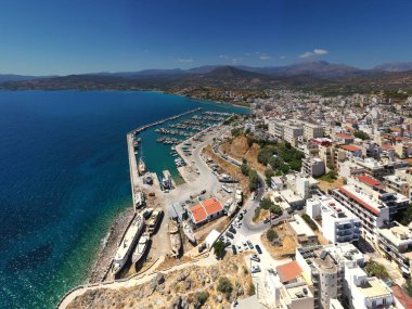 Girit şehrinin panoramik görüntüsü deniz kenarındaki setin üzerindeki beyaz evler insansız hava aracından çekiliyor. 