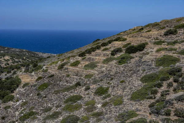 ancient stone mills and their ruins on the slopes of the mountains in Crete on a sunny day