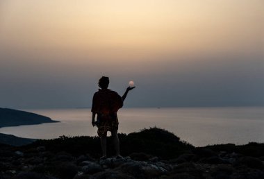 Deniz dağlarının arka planında kırmızılı kadın ve Girit adasında mavi gökyüzü. 