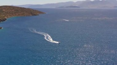 Mavi suda hareket eden bir sürat teknesinin panoramik görüntüsü İHA 'dan çekiliyor.