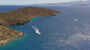 Mavi suda hareket eden bir sürat teknesinin panoramik görüntüsü İHA 'dan çekiliyor.