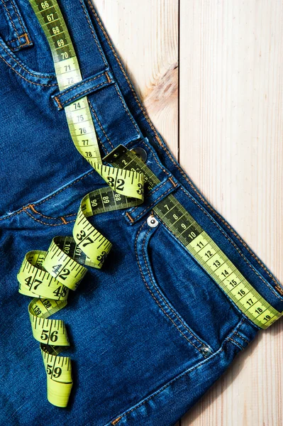 Kot pantolon ve bir ölçüm bandı. Weight.fruits kilo kaybı için kaybetme kavramı