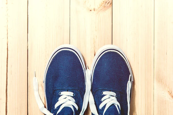 Blue sneakers on wooden background with copy space. Top view. — Stock Photo, Image