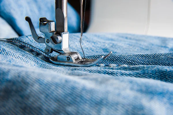 Sewing machine and blue jeans fabric. — Stock Photo, Image