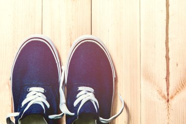 Ahşap arka planda fotokopi alanı olan mavi spor ayakkabılar. Üst görünüm. 