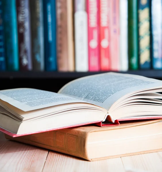 Offenes Buch auf dem Tisch Bücherregale Hintergrund — Stockfoto