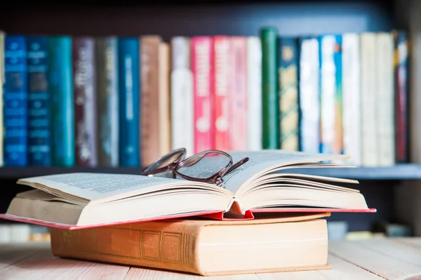 gözlük ve arka plan kitaplık üzerinde kitap