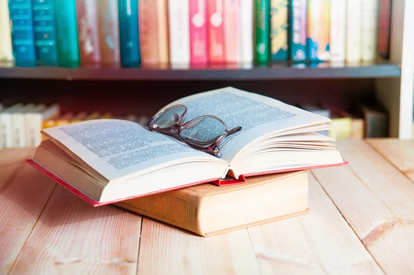 gözlük ve arka plan kitaplık üzerinde kitap