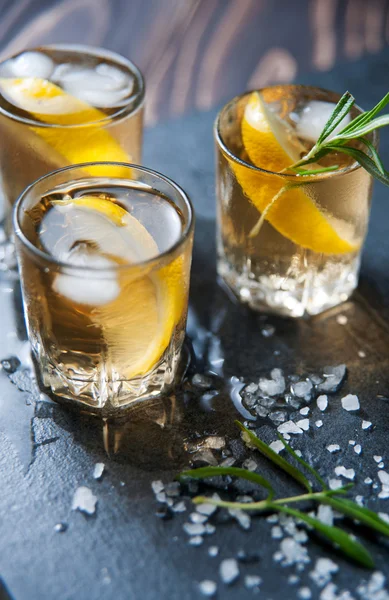 Coquetel de álcool com gelo e alecrim fumante em limão de mesa escuro — Fotografia de Stock