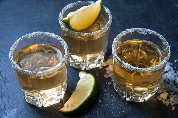 Tequila tiro com limão e sal marinho na mesa preta — Fotografia de Stock