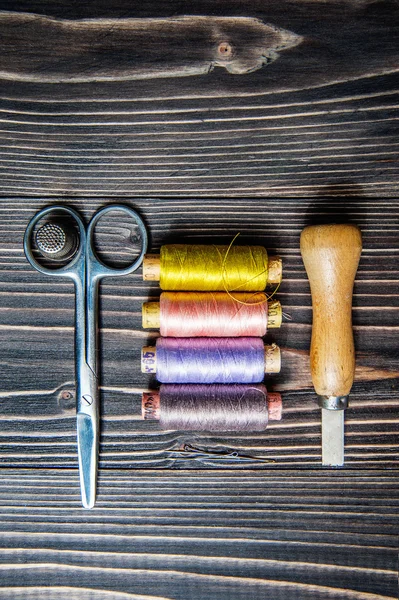 Аксессуары для шитья на темном деревянном столе — стоковое фото