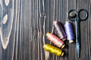 Koyu ahşap masa üzerinde dikiş aksesuarları