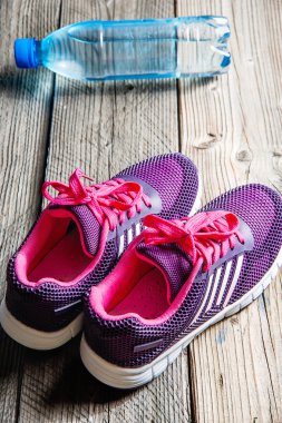 Spor donatımı. Spor ayakkabı, su ahşap arka plan üzerinde.