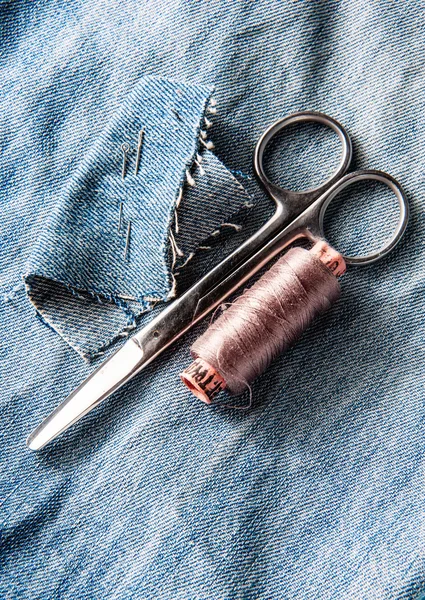 Sewing kit from threads, scissor and needle on jeans backround — Stock Photo, Image