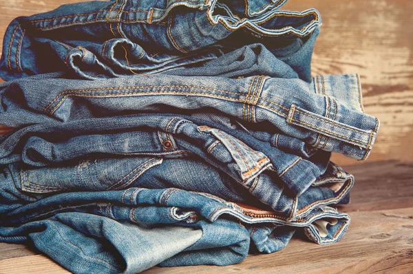 Pilha de jeans de índigo velho ganga na mesa de madeira — Fotografia de Stock