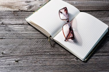 Not defterini açın boş ve ahşap masa gözlük