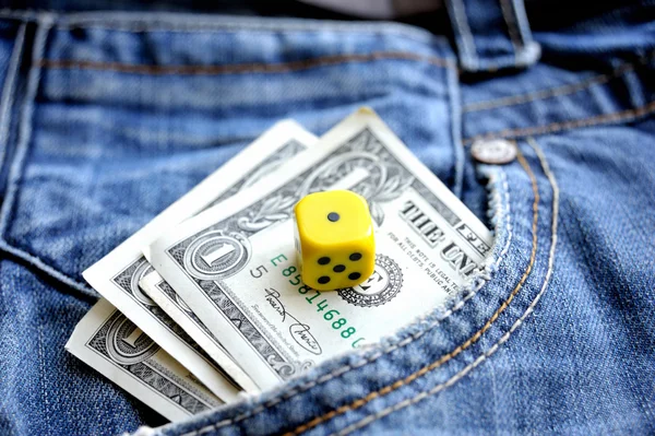 Un dollaro in denim tascabile e un dado — Foto Stock