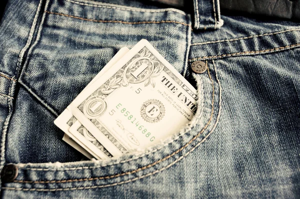Una banconota da un dollaro in una tasca di blue jeans. Vintage tonica . — Foto Stock