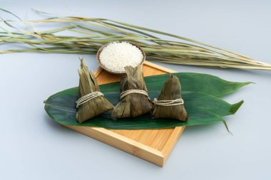 Bambu tepsisinde üç zongzi. Bambu tepsisinde üç pirinç köftesi.