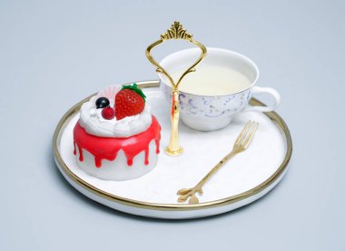 Beyaz bir porselen tabağa parlak ve renkli bir kremalı pasta yerleştirilir. Renkli meyveli pastayla çay zamanı.