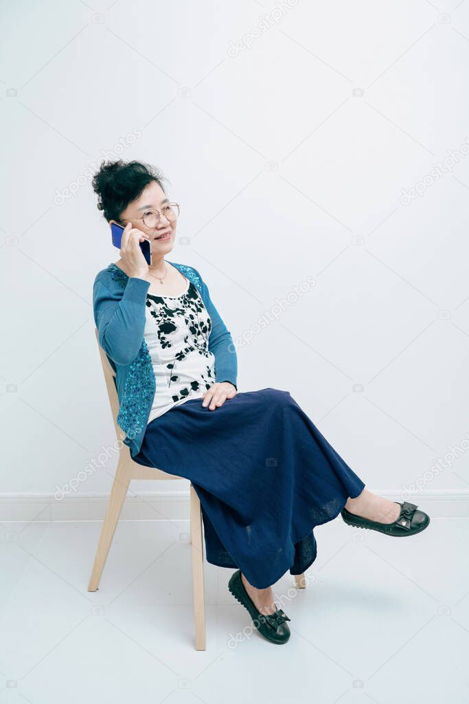 Middle-aged lady sitting on a chair and calling