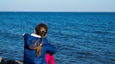 Sonbaharda su yüzeyini izleyen kız