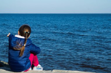 Sonbaharda su yüzeyini izleyen kız