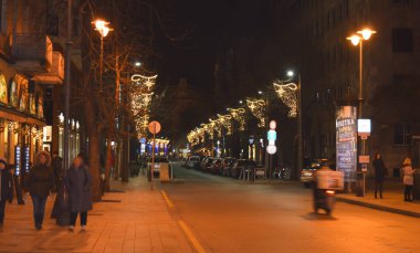 Noel zamanı, dükkanlar, ağaçlar ve insanlarla Budapeşte caddesinin bulanık görüntüsü. Arkaplan olarak kullanılabilir.