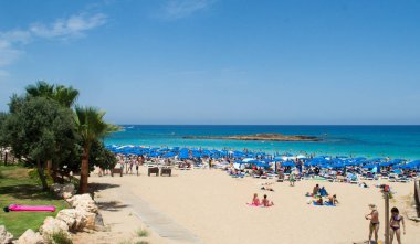 PROTARAS, CYPRUS - 16 Haziran 2018 'de Kıbrıs Rum Kesimi' nin Protaras kentinde güneşli bir günde yerel belediye plajı insanlarla dolup taşıyor. 