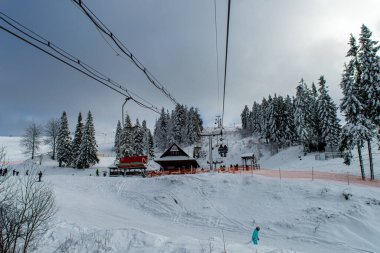 KYIV, SLAVSKE- JANUARY 12020: Kayakçılar 1 Ocak 2020 'de Ukrayna' nın Slavske kentindeki Zakhar Berkut dağına kayak asansöründe. 