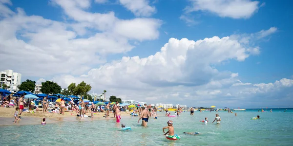 PROTARAS, CYPRUS - 16 Haziran 2018 'de Kıbrıs Rum Kesimi' nin Protaras kentinde güneşli bir günde yerel belediye plajı insanlarla dolup taşıyor. 