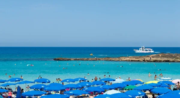 PROTARAS, CYPRUS - 16 Haziran 2018 'de Kıbrıs Rum Kesimi' nin Protaras kentinde güneşli bir günde yerel belediye plajı insanlarla dolup taşıyor. 