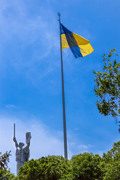 KYIV, UKRAINE - MAY 16,2021: The Motherland monument. Symbol of Kyiv (Kiev). The national flag of Ukraine.