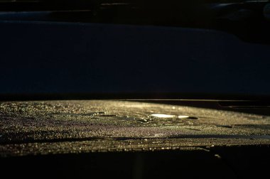 Gün doğumunda arabadaki çiy damlaları