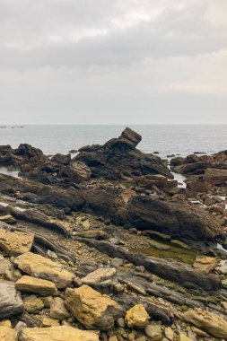 A beautiful seaside village with colorful houses, fishing boats, and green mountains in Ribadesella, Spain.