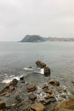 A beautiful seaside village with colorful houses, fishing boats, and green mountains in Ribadesella, Spain.