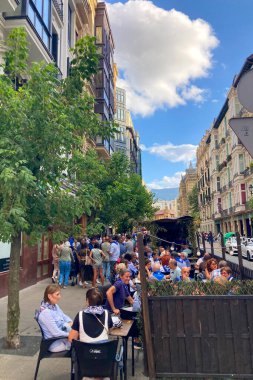 BILBAO, SPAIN - 20 AĞUSTOS 2025: Bulutlu bir günde Bilbao, İspanya 'nın sessiz caddelerinde yürümek, modern binalardan yansıyan yumuşak bir ışık ve şehri kaplayan sakin, karamsar bir atmosfer.