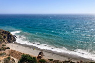 La Herradura, Endülüs, İspanya 'da dalgalı dalgalar ve dramatik kıyı ışıklarıyla hafif fırtınalı bir Akdeniz..