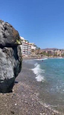 ALMUNECAR, SPAIN - 28 AĞUSTOS 2025: Fırtınalı Akdeniz Almunecar, Endülüs, İspanya 'daki güneşli plaja vuran derin mavi dalgalar.