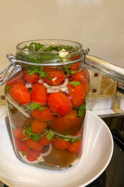 Maydanoz, soğan ve sarımsaklı ev yapımı domates turşusu taze otlar ve tuzlu sulardan oluşan canlı, aromatik bir karışım yaratır..