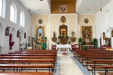 TORREMOLINOS, SPAIN - 29 Ekim 2025: Torremolinos, İspanya 'daki Aziz Mikail Kilisesi' nin içinde zarif mimari, sıcak aydınlatma ve dingin kutsal detaylar bulunmaktadır..